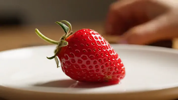 A strawberry on a white plate